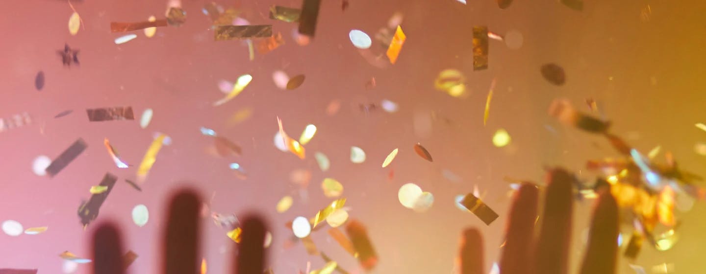 gold confetti raining down with close up of hands in the foreground representing joy at adrien weinert joining firefish